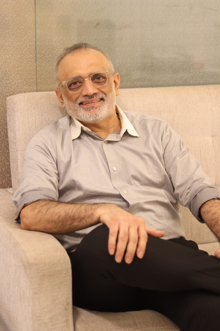 Abhijit Bhave relaxed on a sofa, mid-conversation